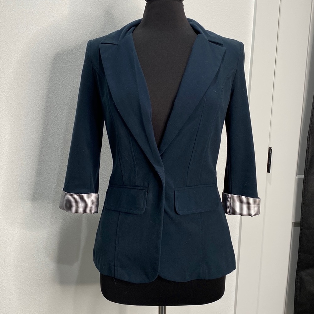 Navy blue fitted blazer with 3/4 length sleeves, small striped detail cuff